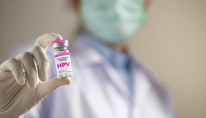 HPV (Human Papillomavirus) Doctor or scientist holding liquid vaccines HPV vaccine. viruses Some strains infect genitals and can cause cervical cancer.